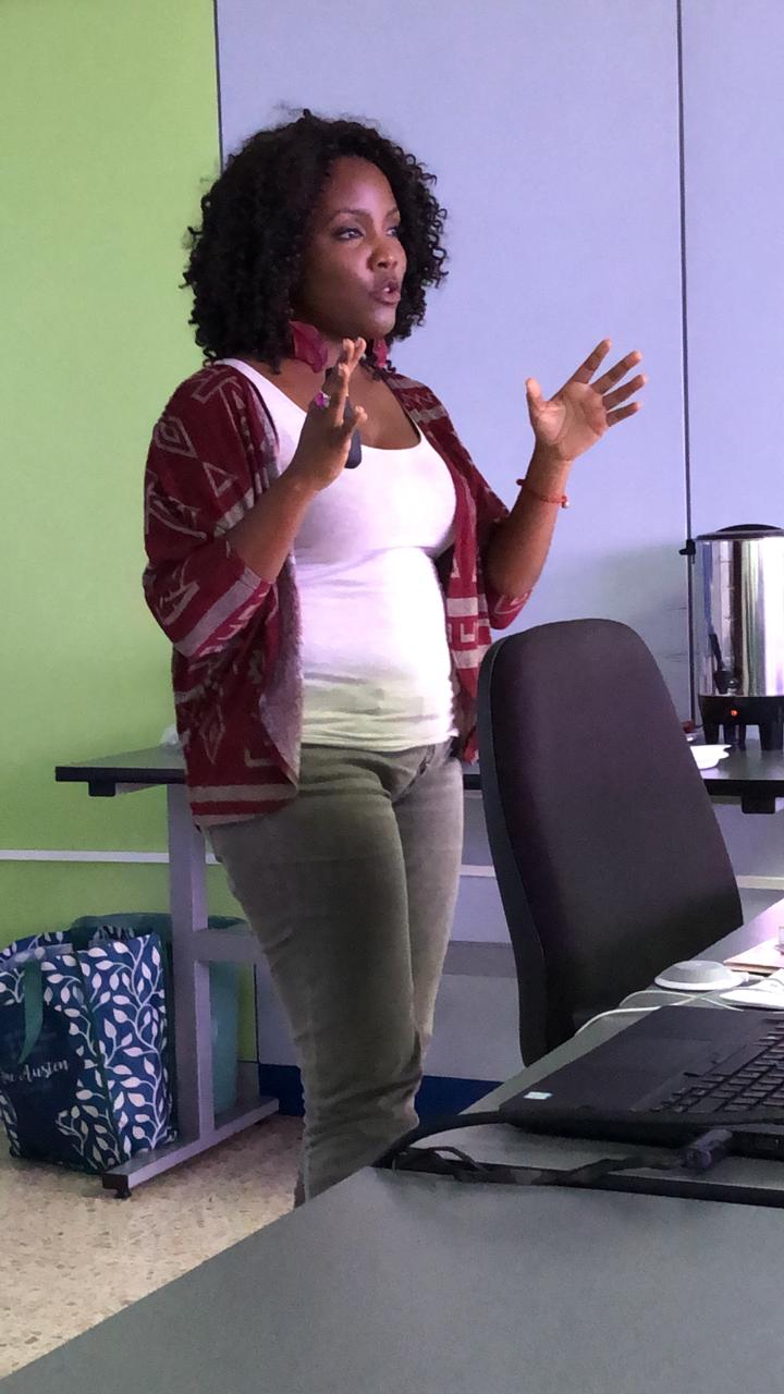 Mujer afrodescendiente explicando con ademanes un tema